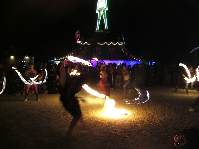 Fire dancers near the man