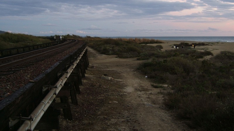 Surfers headed home, crossing under the tracks.