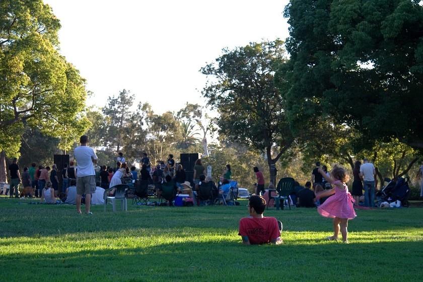 Little girl and others enjoying the music in the park