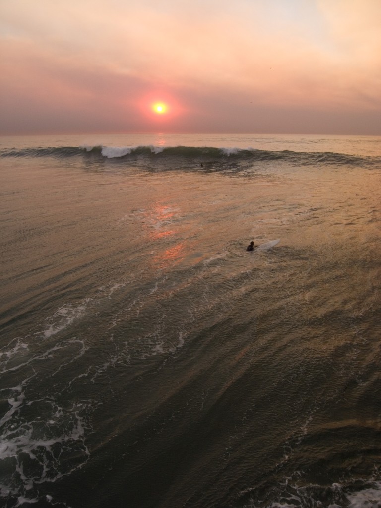 Surfers and a smokey sunset