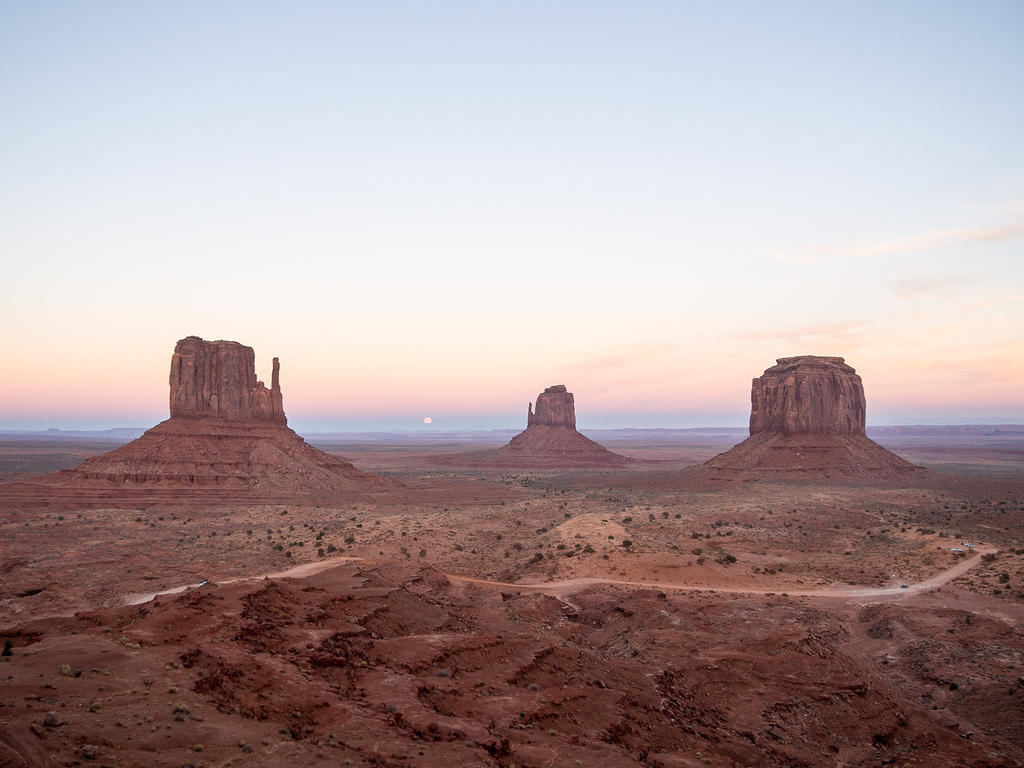 Monument Valley sunset, start of moon rise between the mittens