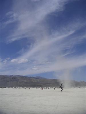 A dust devil moves behind the glass blower sculpture