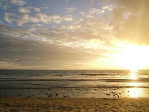 Rain, sun, and surfers at San Onofre beach.