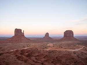 Monument Valley sunset, start of moon rise between the mittens